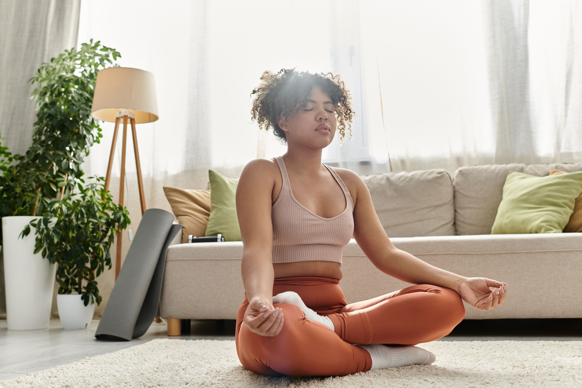 A young woman meditates peacefully at home on a serene afternoon, embracing tranquility and calmness