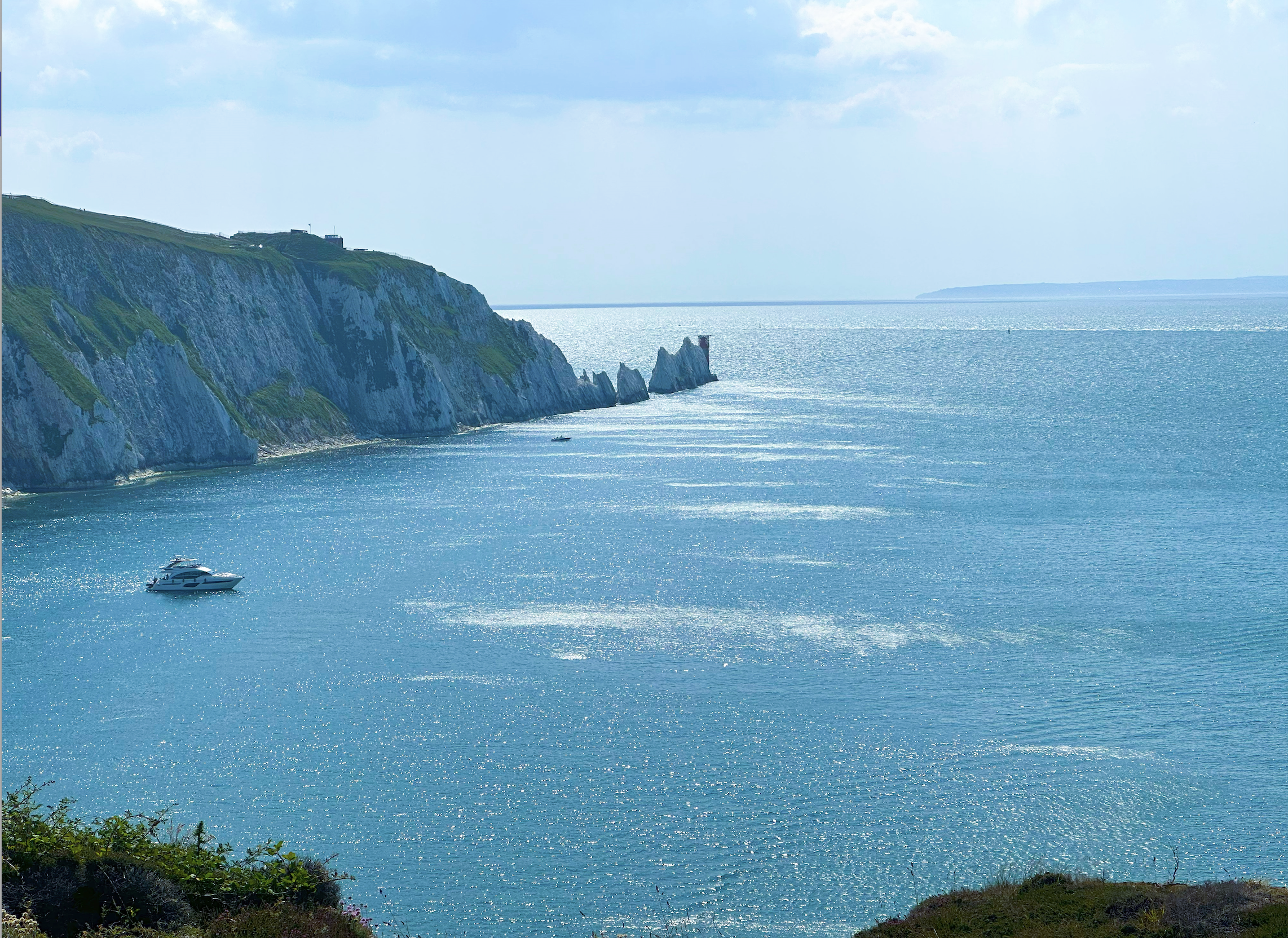 View of The Needles at Alum Bay on a sunny day with clear blue water and sky.
